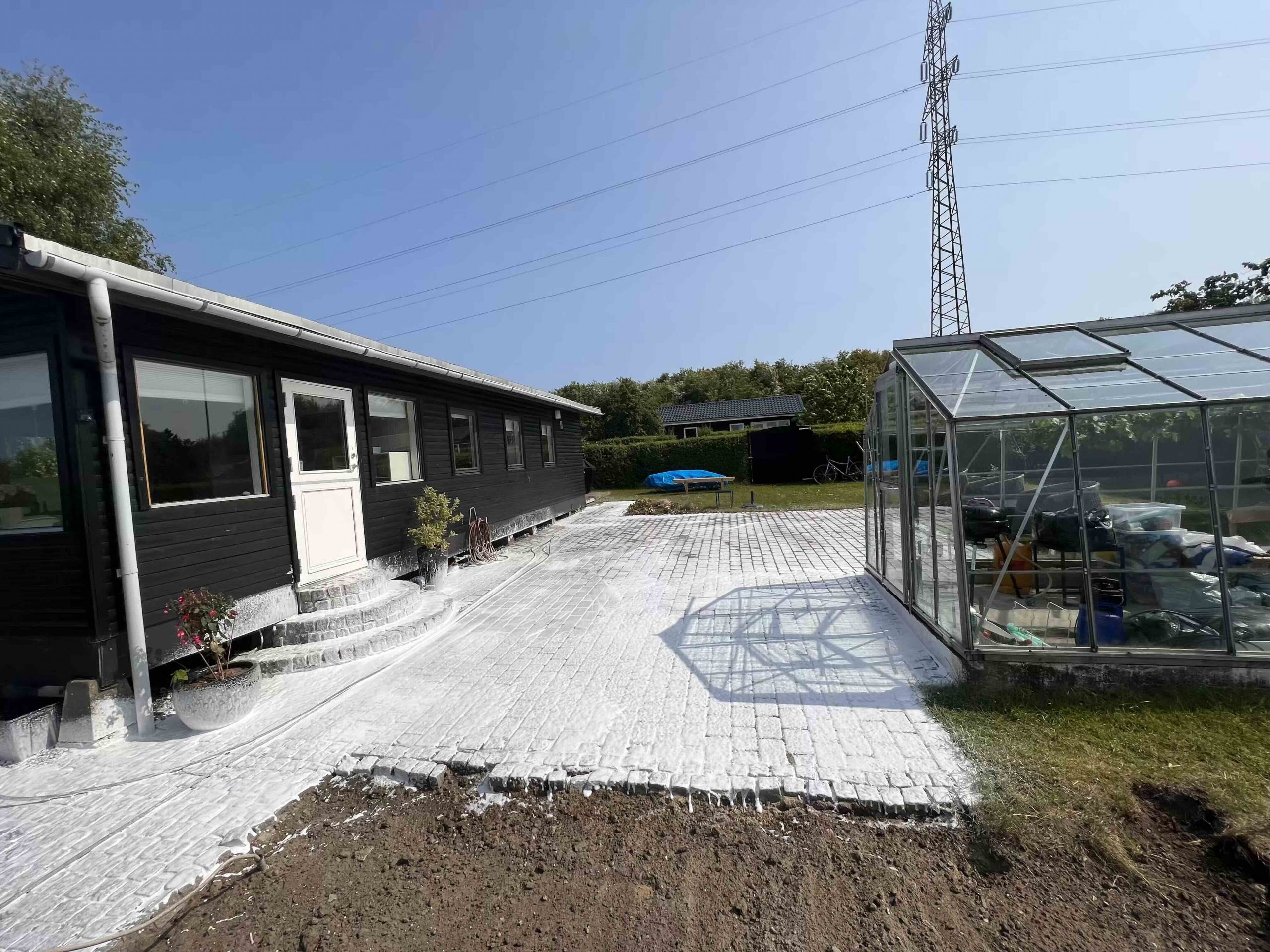 Algebehandling af belægning foran hus