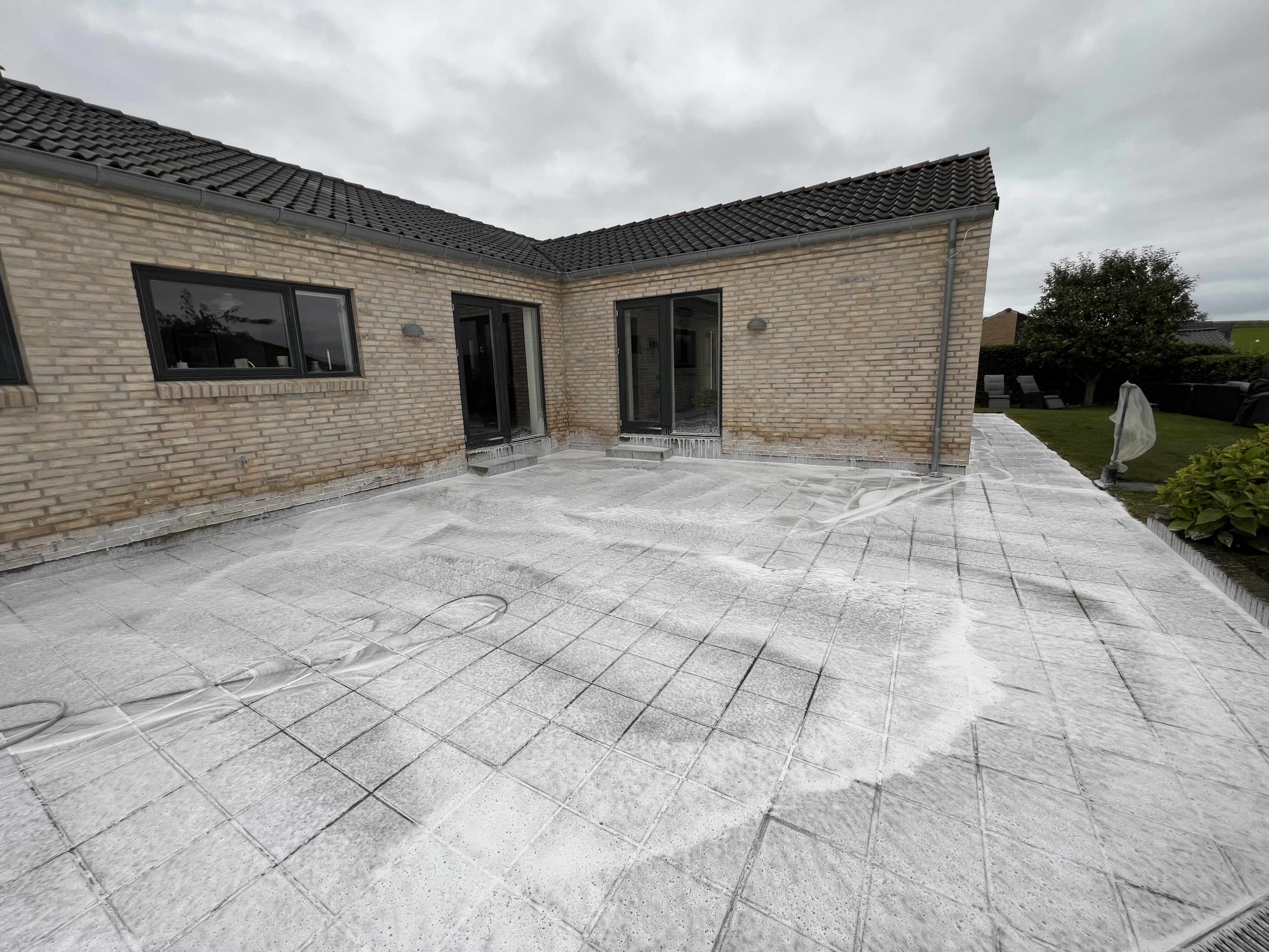 Algebehandling af terrasse flisebelægning